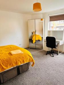 a bedroom with a bed and a mirror and a chair at Private Room close to Leeds University and City centre in Leeds