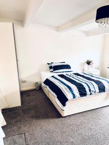 a bedroom with a bed with blue and white stripes at Private Room close to Leeds University and City centre in Leeds