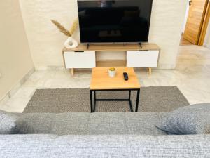 a living room with a tv and a coffee table at The Sunny 15 in Casablanca