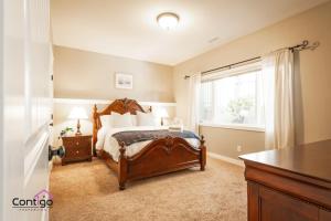 a bedroom with a large bed and a window at Peaceful 2 BD Oasis, Bsmt Suite, Private Terrace, Near YQL in Lethbridge