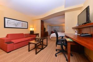 um quarto de hotel com um sofá vermelho e uma secretária em Courtyard Mt. Holly Westampton em Westampton Township