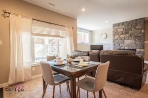 a living room with a table and a couch at Peaceful 2 BD Oasis, Bsmt Suite, Private Terrace, Near YQL in Lethbridge