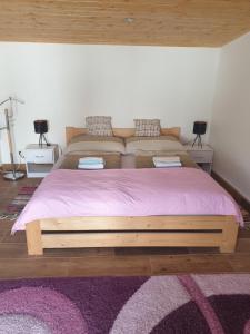 1 cama con marco de madera en un dormitorio en Apartman Diana, en Boldogkőváralja