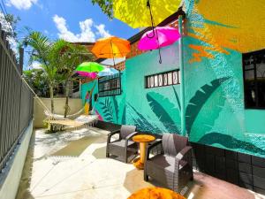 une terrasse avec une table, des chaises et des parasols dans l'établissement Baku Laureles Hostel, à Medellín
