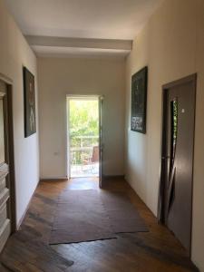 an empty hallway with a door leading to a patio at Art House Hostel Aleksandr in Kutaisi