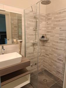 łazienka z umywalką i przeszkloną kabiną prysznicową w obiekcie LA CASA DI TALIN w mieście Serravalle delle Langhe