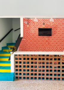 a room with a staircase and a wall of drawers at Baku Laureles Hostel in Medellín