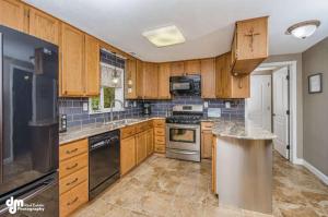 a kitchen with wooden cabinets and stainless steel appliances at Lakefront Perfect for Families/Corporate Rentals in Wasilla