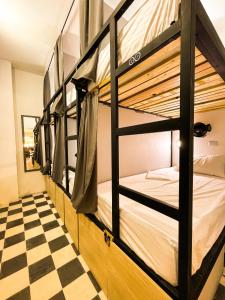 a room with bunk beds and a checkered floor at Baku Laureles Hostel in Medellín