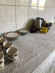 un gruppo di tazze e piatti seduti su un bancone di Art House Hostel Aleksandr a Kutaisi