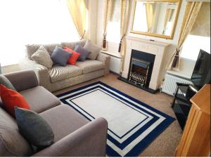 a living room with a couch and a fireplace at Lake District Holiday Home, near Ennerdale Lake - Inglenook 06 - Free Wifi in Workington