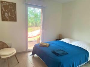 ein Schlafzimmer mit einem blauen Bett und einem Fenster in der Unterkunft Appartement de standing avec piscine et plage à pieds in La Croix-Valmer