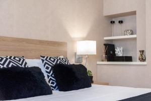 1 dormitorio con 1 cama con almohadas blancas y negras en Elegante Apartamento Centrico, en Vigo