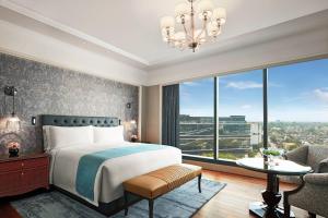 a bedroom with a bed and a large window at The Ritz-Carlton, Pune in Pune