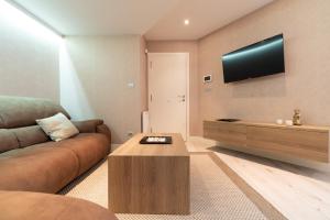 sala de estar con sofá y TV de pantalla plana en Elegante Apartamento Centrico, en Vigo