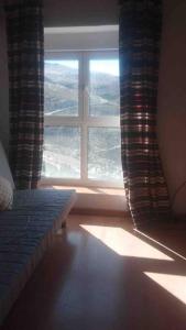 una camera da letto con una grande finestra con vista di DUPLEX ALCAZABA con parking gratuito, 2 dormitorios , 5pax a Sierra Nevada