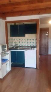 una cucina con elettrodomestici bianchi e blu e un pavimento in legno di DUPLEX ALCAZABA con parking gratuito, 2 dormitorios , 5pax a Sierra Nevada