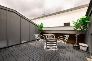 a patio with a table and chairs on a balcony at Wild Roses Serviced Apartments - ExCel Warehouse 2 in London