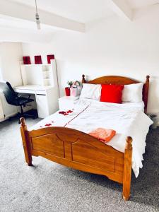 Un dormitorio con una gran cama de madera con almohadas rojas en Private Room close to Leeds University and City centre, en Leeds