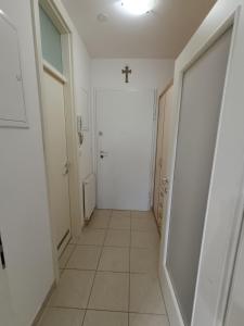 un pasillo con una puerta blanca y una cruz en la pared en Apartman Tino en Zagreb