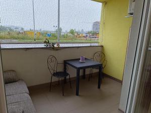 a small table and chairs in a room with a window at Apartman Tino in Zagreb