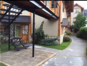 a bench sitting in the courtyard of a building at Apartamento San Martín de los Andes in San Martín de los Andes