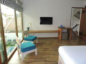 a room with a bed and a tv on a wall at Binnacle Negombo in Negombo