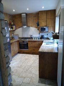 een keuken met houten kasten en een fornuis met oven bij Characterful stone cottage in Uffington 