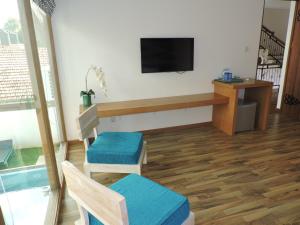 a living room with two chairs and a television at Binnacle Negombo in Negombo