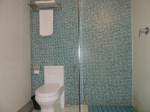 a bathroom with a toilet and a glass shower at Binnacle Negombo in Negombo