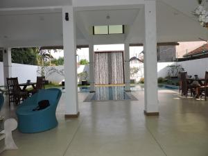 a living room with a blue couch and a pool at Binnacle Negombo in Negombo