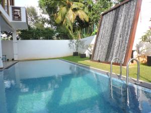 a swimming pool in a house with a white fence at Binnacle Negombo in Negombo