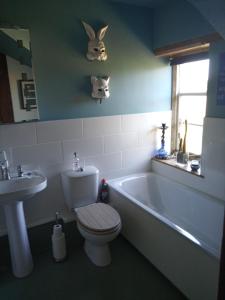 een badkamer met een toilet, een bad en een wastafel bij Characterful stone cottage in Uffington 