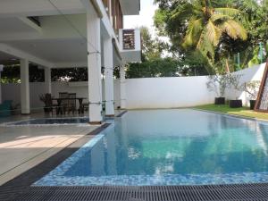 a swimming pool in the backyard of a villa at Binnacle Negombo in Negombo