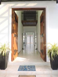 an open hallway with wooden doors and plants at Binnacle Negombo in Negombo