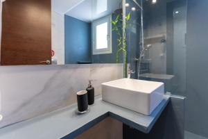 a bathroom with a white sink and a mirror at Sea Breeze Suite Next to Flisvos Marina & Beach in Athens