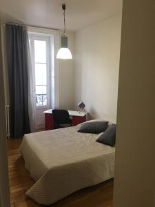 een slaapkamer met een bed, een bureau en een raam bij Saint-Louis : Saint-Étienne appart de 125 m2 centre-ville 4 chambres,4 lits king size in Saint-Étienne