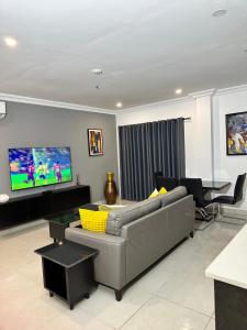 sala de estar con sofá, mesa y TV en Westlands Tower - Ghana Villas, en Accra