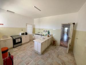 a large kitchen with white cabinets and a stove at Casa dos Rebolinhos in Sagres