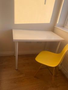 a white desk and a yellow chair in a room at IServe in Parkside