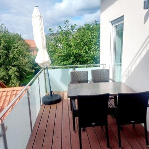 a table and chairs on a balcony with an umbrella at Fewo.Gomaringen in Gomaringen