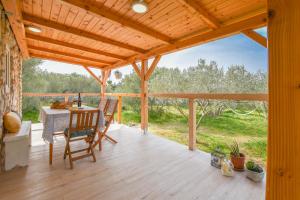 une terrasse en bois avec une table et des chaises. dans l'établissement House Fiona, à Kraj