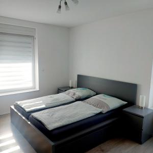 1 cama en un dormitorio con ventana en Fewo.Gomaringen, en Gomaringen