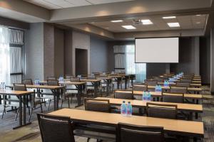 a lecture room with tables and chairs and a white screen at Courtyard by Marriott Richmond Berkeley in Richmond