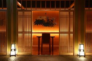 uma mesa com uma cadeira num quarto com duas luzes em Jozankei Daiichi Hotel Suizantei em Jozankei