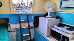 a room with a refrigerator and a fan on a boat at La Perle d'orient A man donné in Gruissan