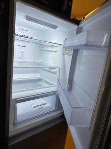 an empty refrigerator with its door open in a kitchen at Condo Unit in BGC Taguig Manila with FREE Covered Parking & WiFi in Manila
