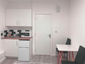 a kitchen with white cabinets and a white door at Seven Studio London in London