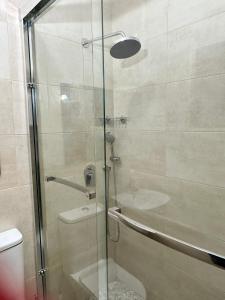 baño con ducha y puerta de cristal en Westlands Tower - Ghana Villas, en Accra