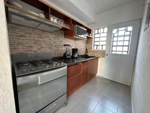 a kitchen with a stove top oven next to a door at Flor de Lantana in Playa del Carmen
